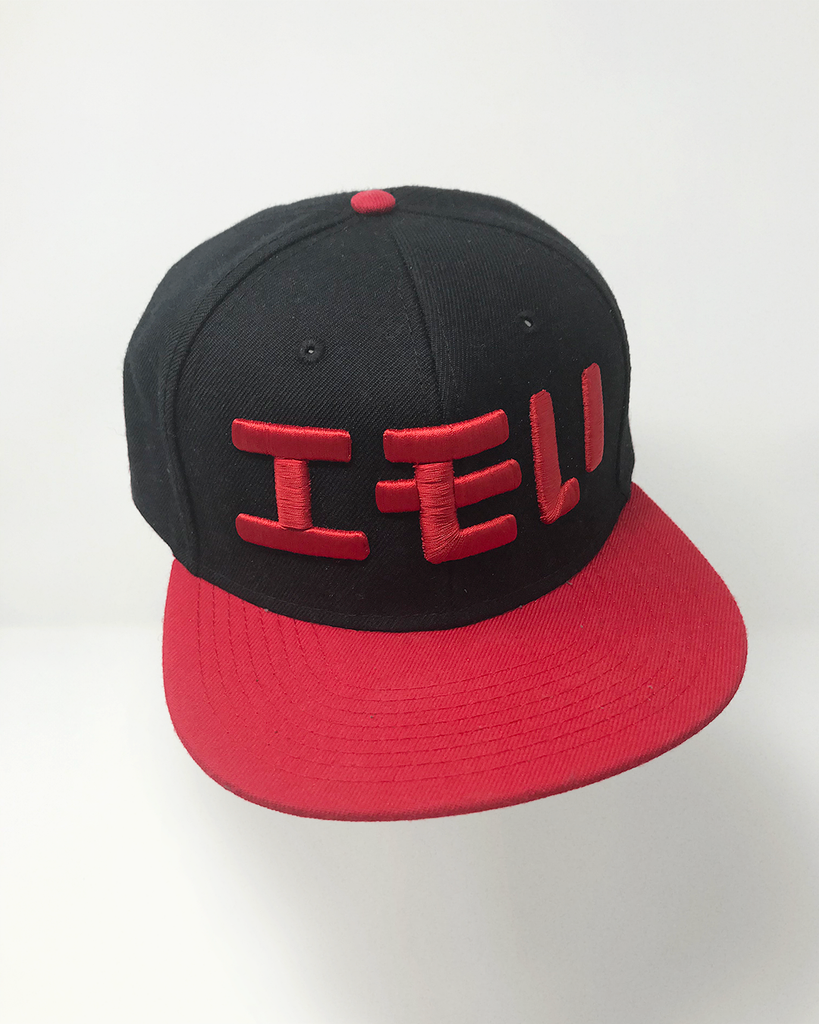 A red and black hat with red embroidery of "エモい" on it
