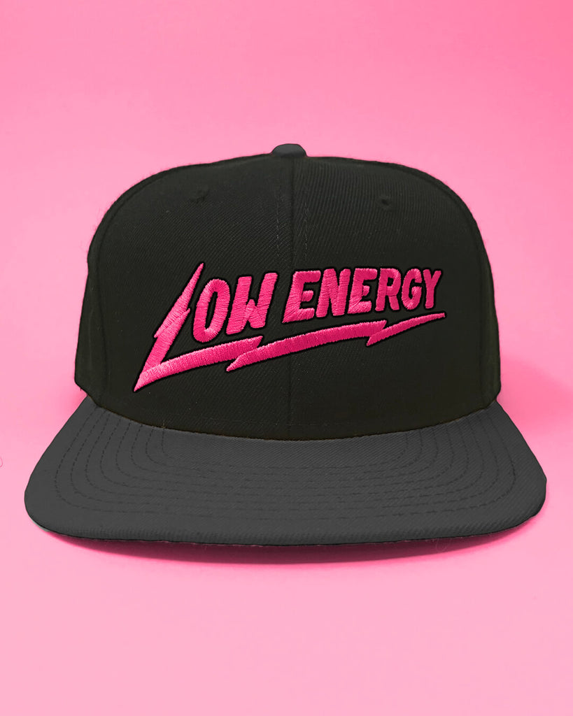 The Low Energy snapback hat in pink and black.