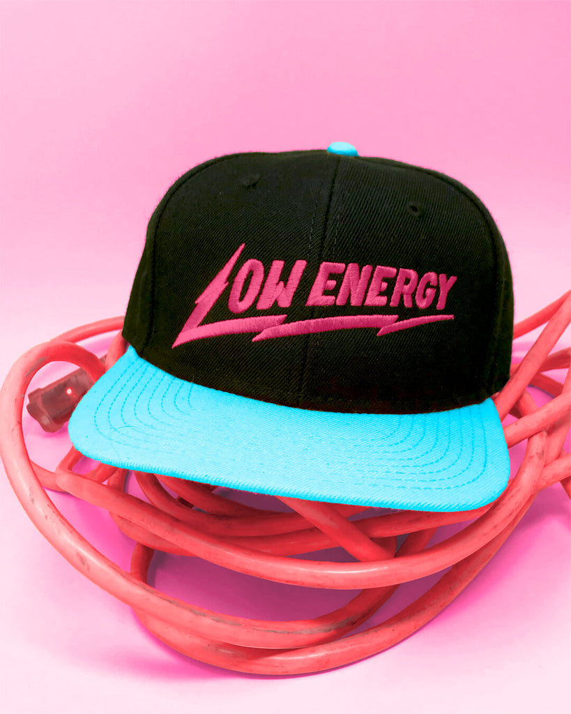 A blue and black snapback hat with Low Energy embroidered on it.